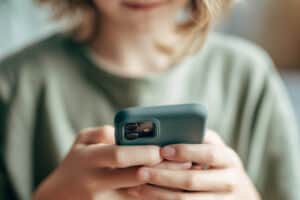 Young person using a phone — generative AI platform risk and child safety